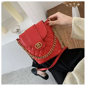Detail of red quilted bucket bag with gold interlocking ring buckle and chain strap