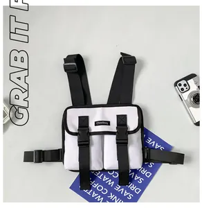 Detail of white tactical chest bag featuring black buckles and double front pockets