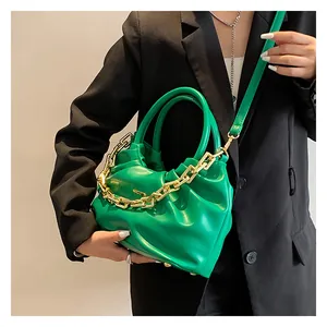 Detail of bright green pleated PU bag featuring chunky gold chain and slim shoulder strap