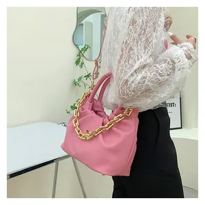 Detailed view of pink pleated PU bag featuring a bold chunky gold chain decoration