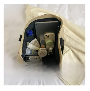 Détail du grand sac cabas en toile contenant une tablette et des produits cosmétiques