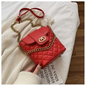 Close-up of red quilted leather bag with gold double-ring lock and chain strap