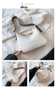 Detail view of white PU leather half-moon shoulder bag with brown strap and zip closure