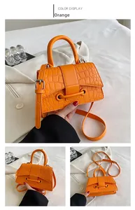 Details der orangefarbenen Handtasche mit Krokodilprägung und verstellbarem Riemen
