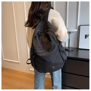 Detailed view of the black nylon casual backpack featuring a minimalist round logo badge