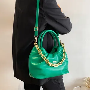 Green ruched PU leather cloud bag with chunky gold chain and crossbody strap worn by model