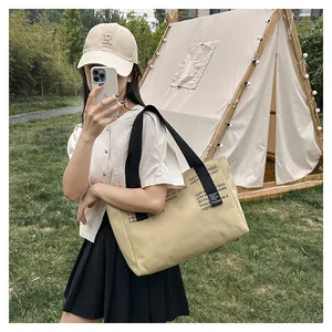 Détail du grand sac fourre-tout en toile avec sangles noires et texte décoratif
