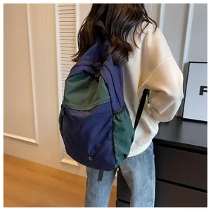 Detail view of navy and forest green nylon backpack showing large side storage pocket