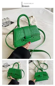 Detail der grünen PU-Handtasche mit Krokoprägung, elegantem Metallstab und Gurt