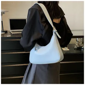 Detail of light blue PU leather hobo shoulder bag with metal buckle in office setting