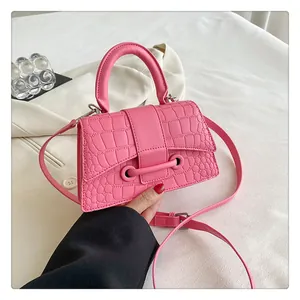 Detail der rosafarbenen Handtasche mit Krokodilprägung, Trapezform und Tragegriff