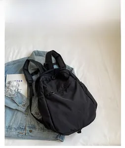 Close-up of black nylon casual backpack featuring breathable mesh shoulder straps and logo