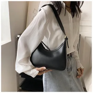 Close-up of a minimalist black PU leather hobo shoulder bag with smooth crescent shape
