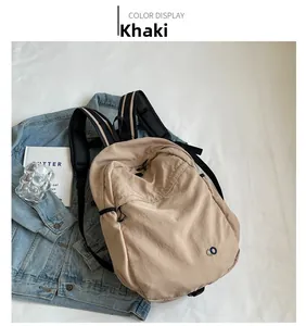Close-up of khaki casual backpack on denim jacket with striped strap details