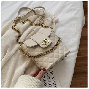 Detailed view of beige quilted bucket bag with gold chain and circular lock closure