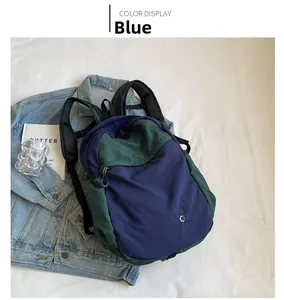 Close-up of stylish blue and green nylon backpack with embroidered CO logo detail