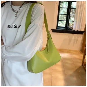 Close-up of avocado green PU leather hobo shoulder bag worn on a model for daily use