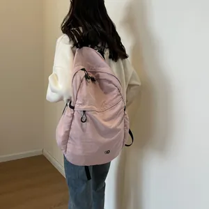Minimalist light pink nylon backpack for women with stylish round logo and casual design