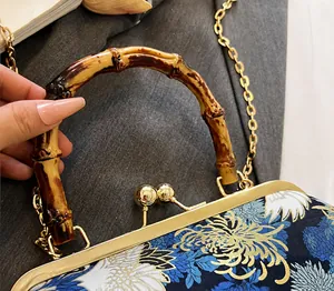 Detail of vintage bag with crane print, natural bamboo handle, and gold metal hinge