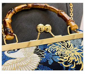 Detail of bamboo handle and gold hardware on retro crane print fabric handbag