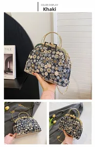 Détail de broderie florale sur un sac vintage avec une poignée ronde en métal doré