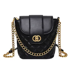 Quilted black leather bucket bag with gold chain strap and turn-lock closure on white background