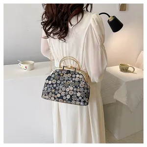 Vue détaillée d'un sac bandoulière floral vintage avec poignée dorée et chaîne