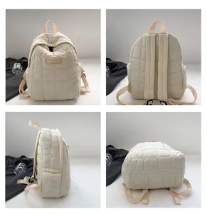 Detail view of beige quilted backpack showing stitching patterns and adjustable straps