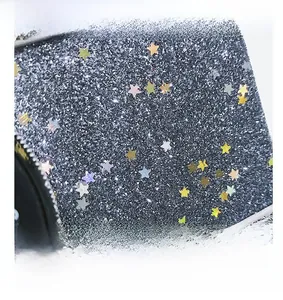 Close-up of glitter camera bag texture with colorful metallic star-shaped sequins