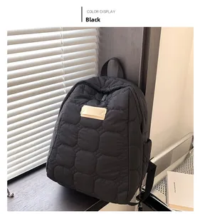 Close-up of black quilted backpack with large check pattern and square logo detail