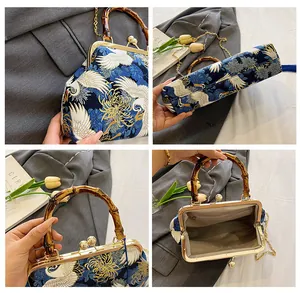 Details van handtas met kraanvogelprint, bamboe handvat en gouden metalen ketting