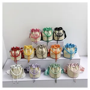 Summer woven bucket bags in various colors with embroidered lettering and crossbody straps