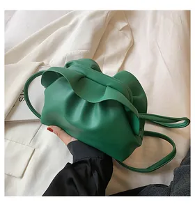 Détail du sac nuage vert avec fine bandoulière et texture de cuir souple plissé
