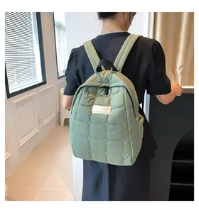 Close-up of quilted light green backpack featuring stylish stitching and logo patch detail