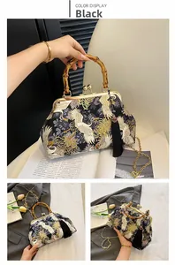 Detail of vintage black handbag with crane embroidery, bamboo handle and gold chain