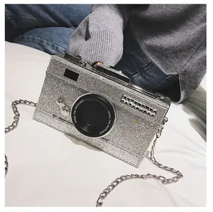 Glittering silver camera-shaped crossbody bag with chain strap and text detail