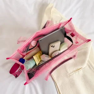 Intérieur de grand sac fourre-tout en mesh rose montrant tablette, téléphone et produits