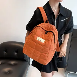 Quilted bright orange backpack for women featuring minimalist stitched square pattern