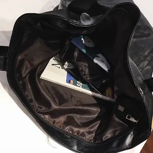 Grande borsa tote punk in pelle PU nera ad alta capacità mostrata con libri e tablet