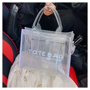Detail view of the white semi-transparent mesh tote bag with lettering inside a car