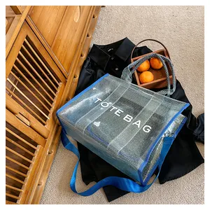 Detailed macro view of the blue mesh PVC tote bag with white TOTE BAG lettering detail
