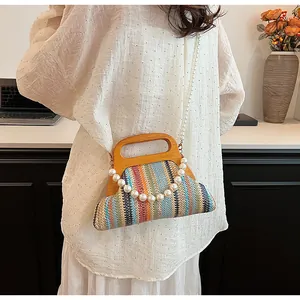 Close-up of colorful striped woven handbag with wooden handle and large pearl strap