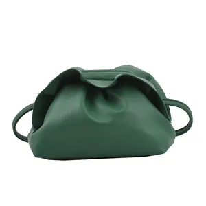 Sac pochette froncé vert foncé minimaliste avec fine bandoulière sur fond blanc