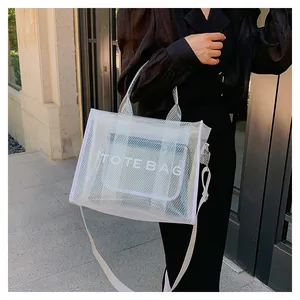 White mesh tote bag detail with TOTE BAG lettering and adjustable crossbody strap