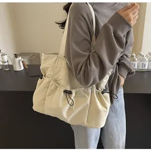 Gedetailleerde weergave van een beige grote tote bag met handige trekkoordzakken