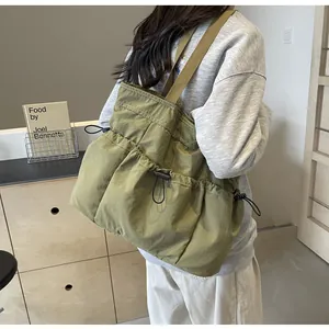 Detail van olijfgroene gewassen nylon draagtas met praktische trekkoordin-zakken