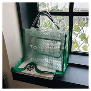 Detail of green transparent mesh tote bag with TOTE BAG lettering and nylon straps