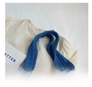 Close-up of blue knit tote bag showing white heart patterns and soft woven texture
