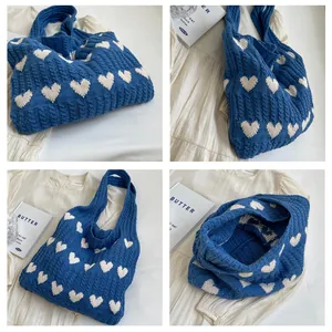 Detailed knit texture of blue heart pattern tote bag with thick braided woolen yarn