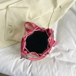Pink straw bucket bag with drawstring closure and stylish letter embroidery detail